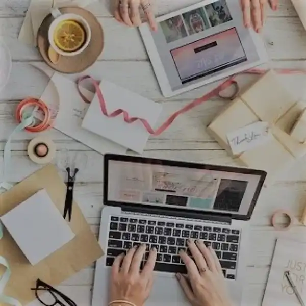 mains qui pianotent sur un ordinateur, des feuilles sur un bureau